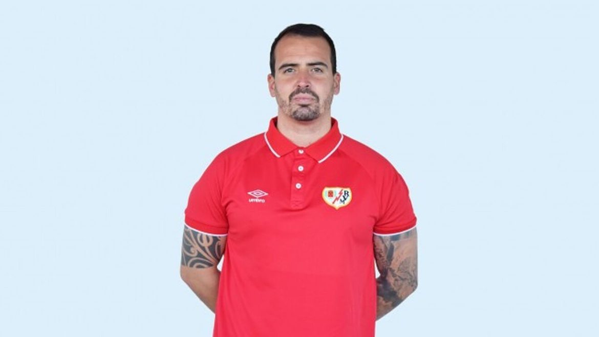 Carlos Santiso, entrenador del Rayo Vallecano femenino vistiendo polo rojo con el escudo del Rayo